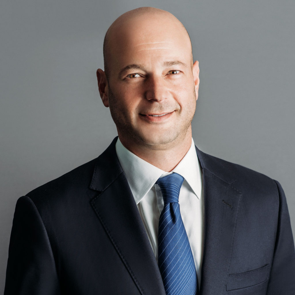 executive jason colodne in a black suit with blue tie