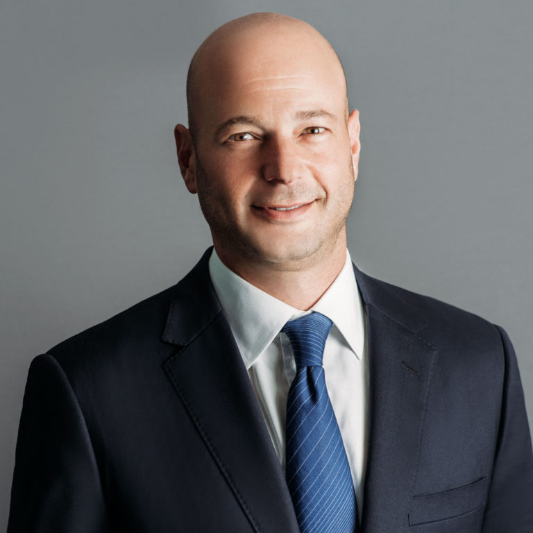 executive jason colodne in a black suit with blue tie